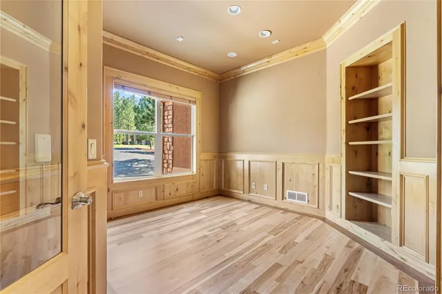 a view of a hallway with wooden floor and closet area