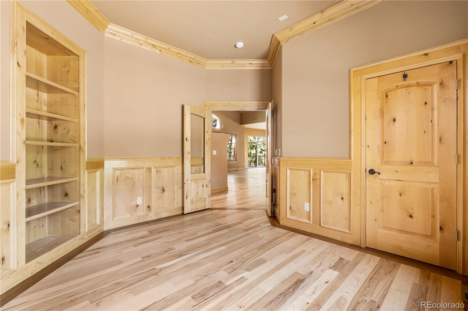 691 Cumberland Road Larkspur, CO 80118 - Photo 23 of 43 a view of a hallway with wooden floor and closet area