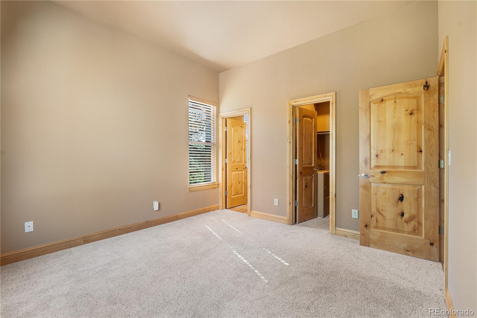 691 Cumberland Road Larkspur, CO 80118 - Photo 27 of 43 an empty room with windows and closet