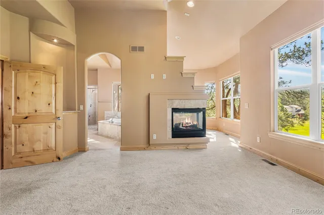 a view of an empty room with window and fire place