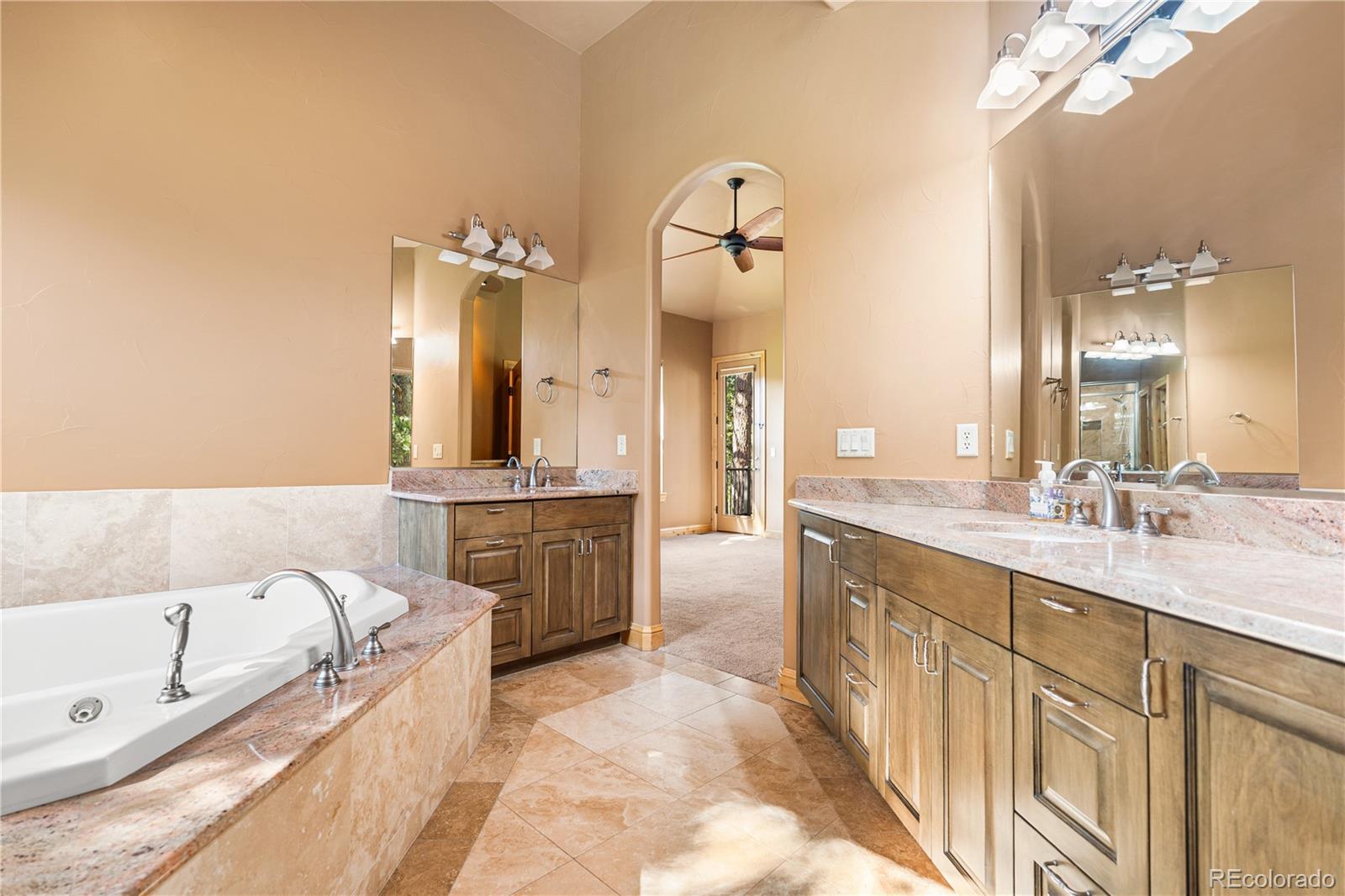 691 Cumberland Road Larkspur, CO 80118 - Photo 33 of 43 a large bathroom with a granite countertop double vanity sink a mirror and a bathtub