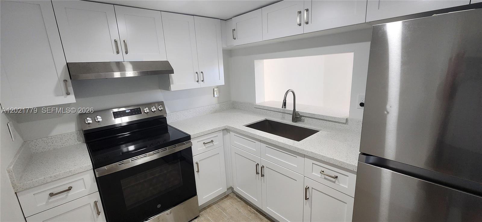 11800 Southwest 18th Street, Unit 4094 Miami, FL 33175 - Photo 4 of 14 a kitchen with white cabinets and black appliances