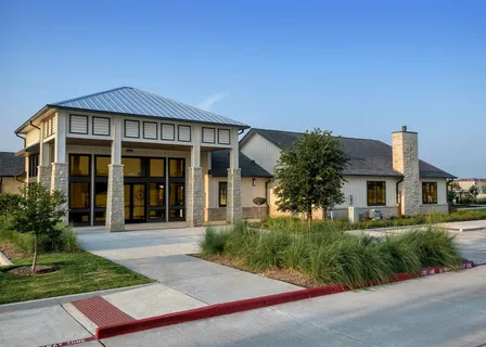 a front view of a house with a yard and potted plants