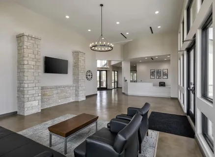 a living room with furniture a flat screen tv and kitchen view