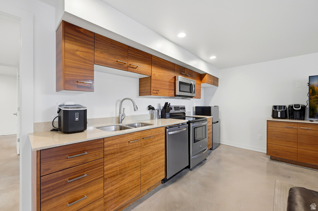 1389 Millbrook Way Bountiful, UT 84010 - Photo 44 of 74 Contemporary kitchen featuring wood-finish cabinetry, light-toned countertops, and stainless steel appliances including a microwave, range, and dishwasher