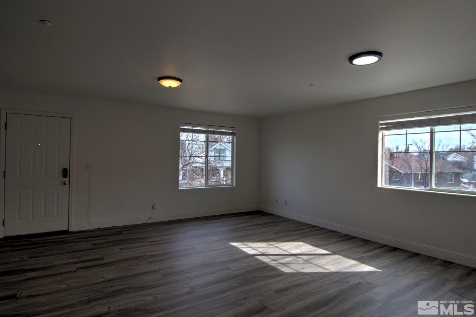 433 Holcomb Avenue Reno, NV 89502 - Photo 7 of 31 an empty room with wooden floor and windows