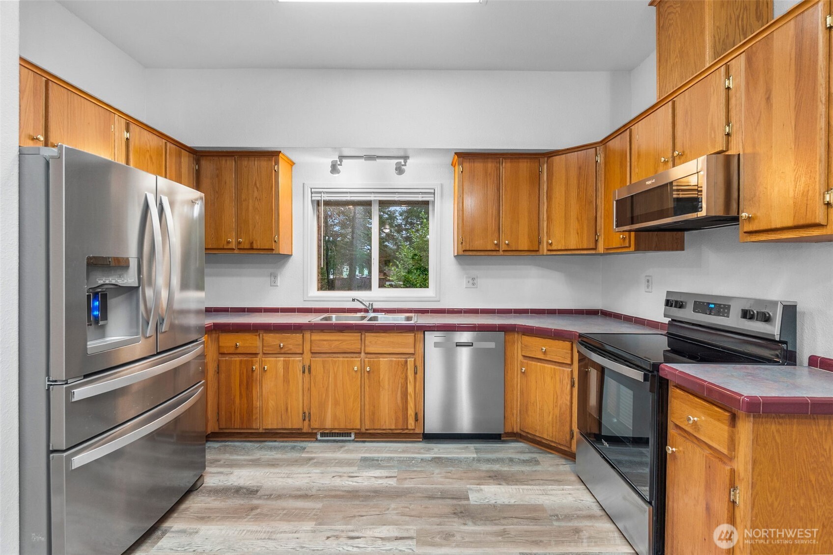 71 East Rhododendron Place Shelton, WA 98584 - Photo 9 of 38 a kitchen with stainless steel appliances granite countertop a refrigerator a sink dishwasher a stove and white countertops with cabinets
