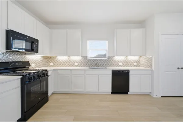 a kitchen with granite countertop white cabinets and stainless steel appliances