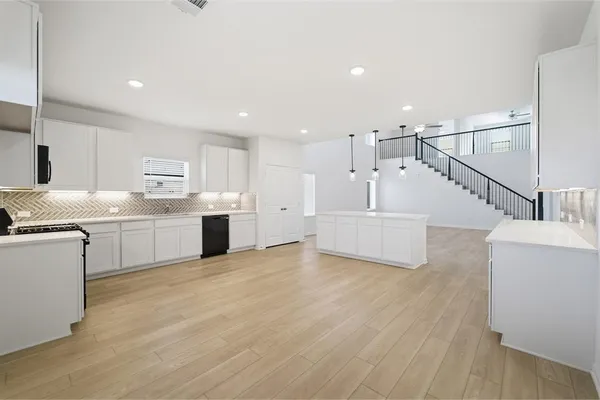 a view of a kitchen with wooden floor and electronic appliances