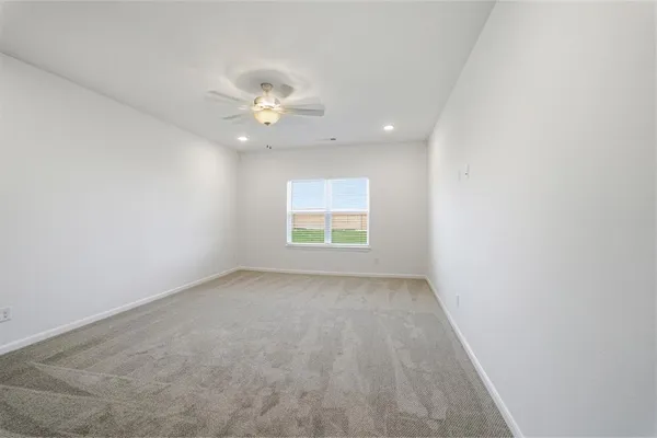 an empty room with a window and a fan