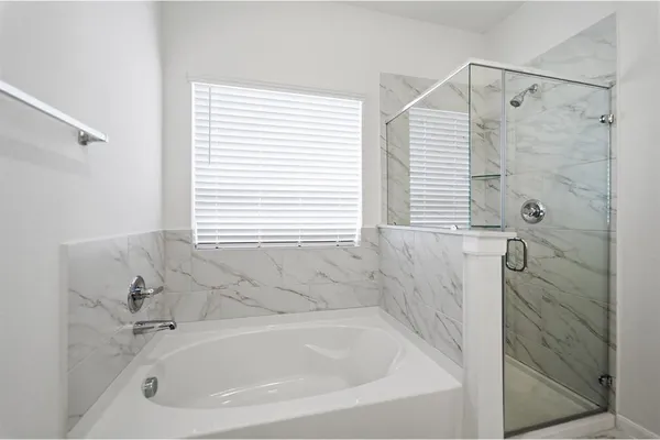 a white bath tub sitting next to a shower