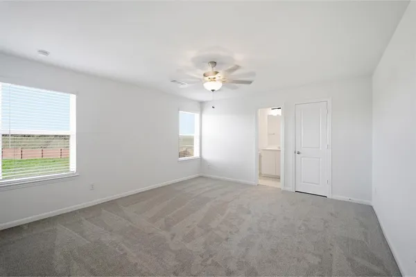 an empty room with windows and ceiling fan