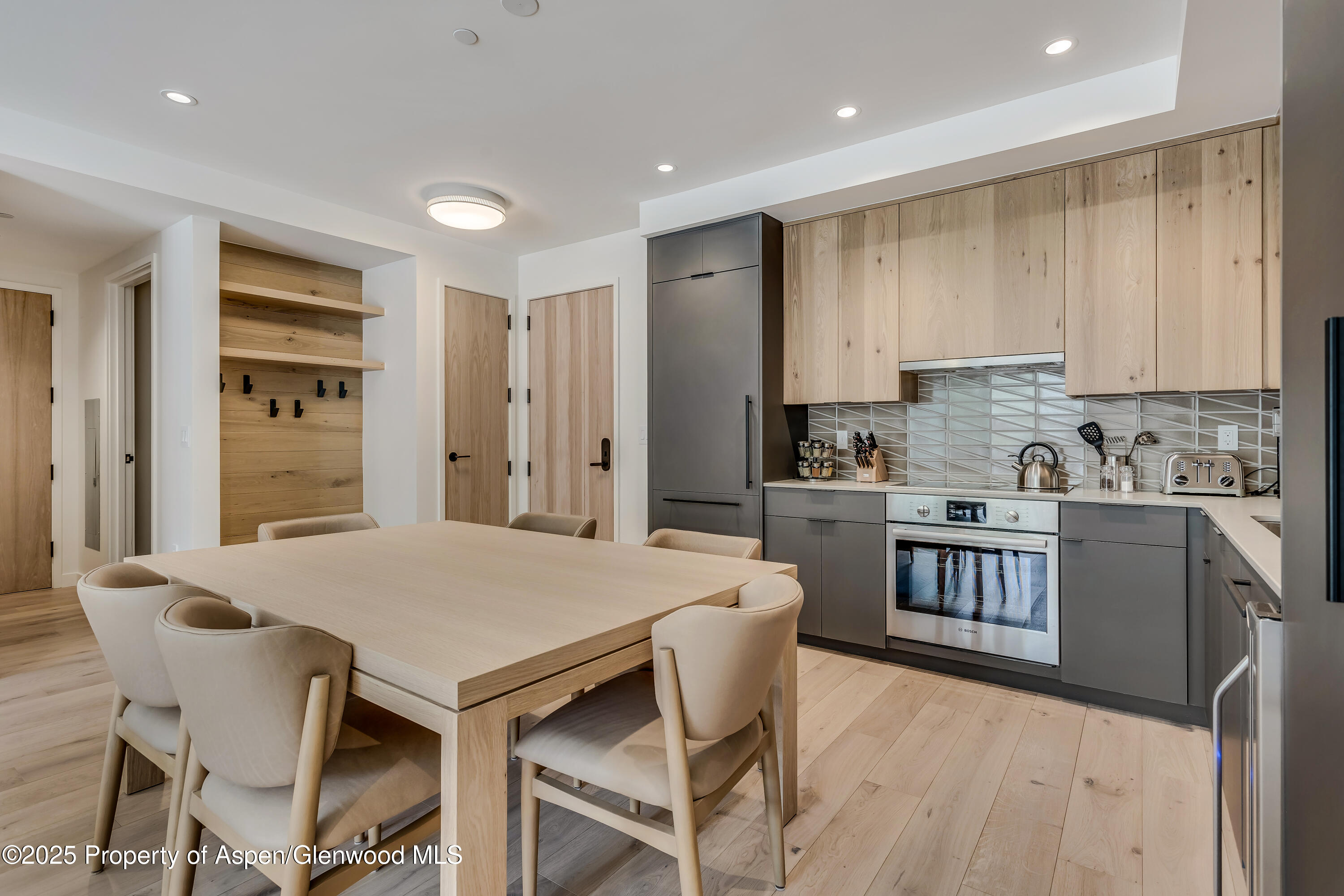 119 Wood Road, Unit 103 Snowmass Village, CO 81615 - Photo 6 of 23 a kitchen with a table chairs refrigerator and cabinets
