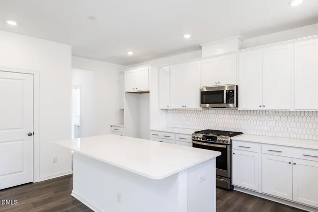 a kitchen with a sink appliances cabinets and a window