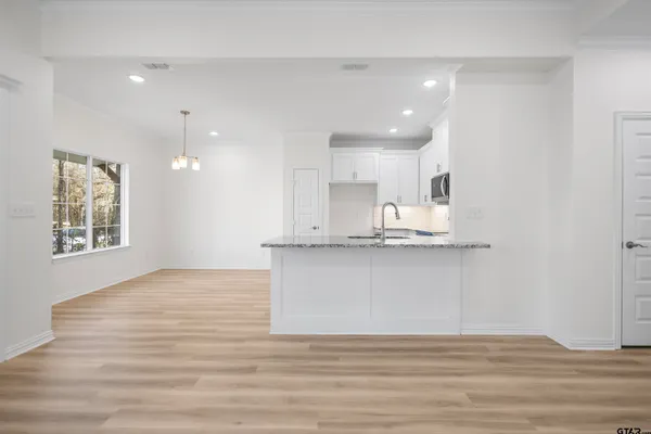 a view of large kitchen with granite countertop a stove top oven a sink and a granite counter top