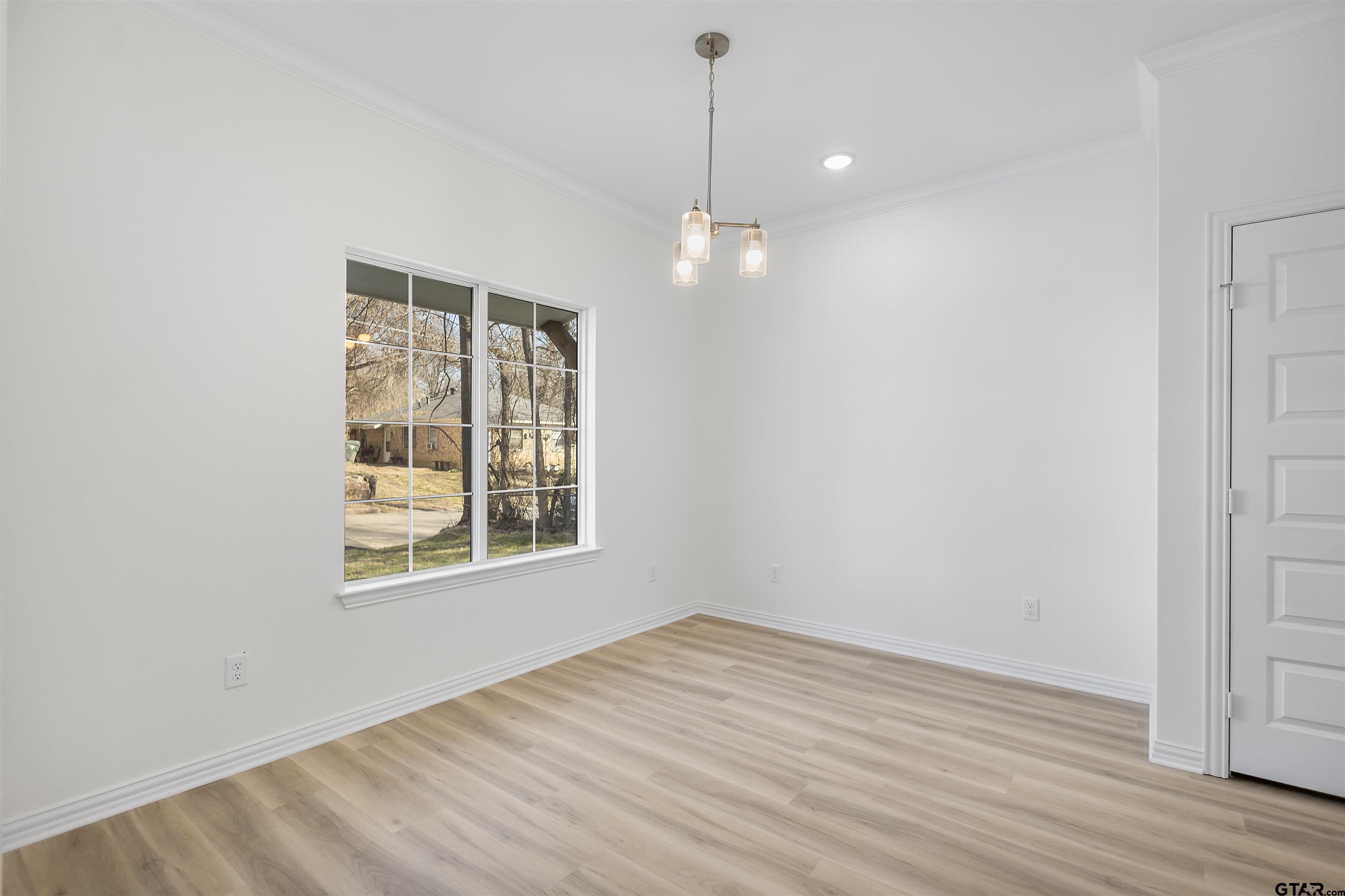 1310 West Claude Street Tyler, TX 75702 - Photo 12 of 27 a view of an empty room with wooden floor and a window