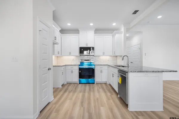a kitchen with granite countertop white cabinets and white appliances