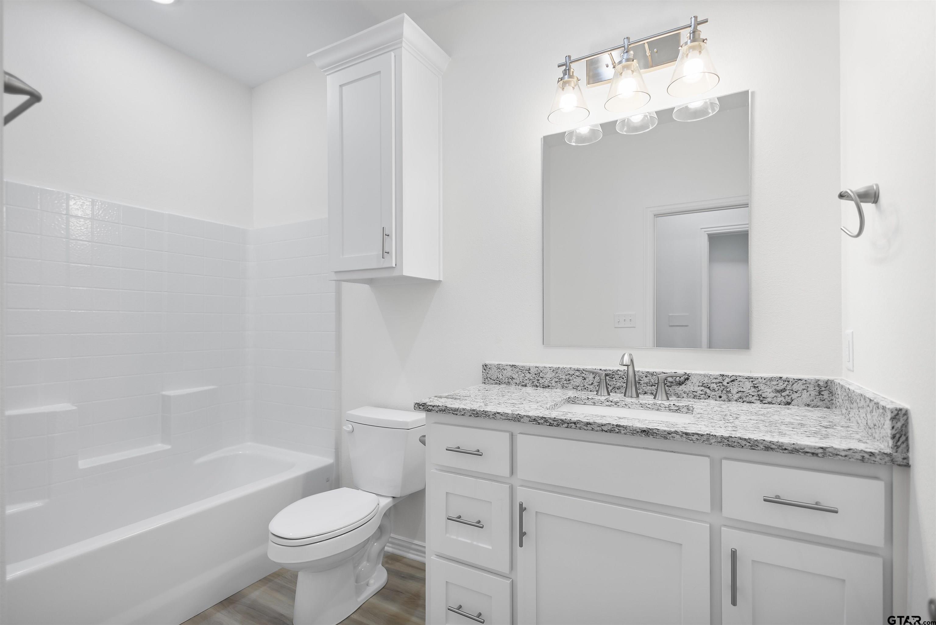1310 West Claude Street Tyler, TX 75702 - Photo 15 of 27 a bathroom with a sink a toilet and bathtub