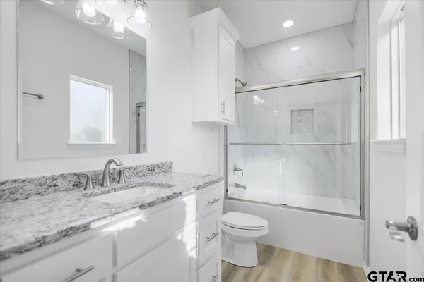 a bathroom with a granite countertop sink toilet and shower