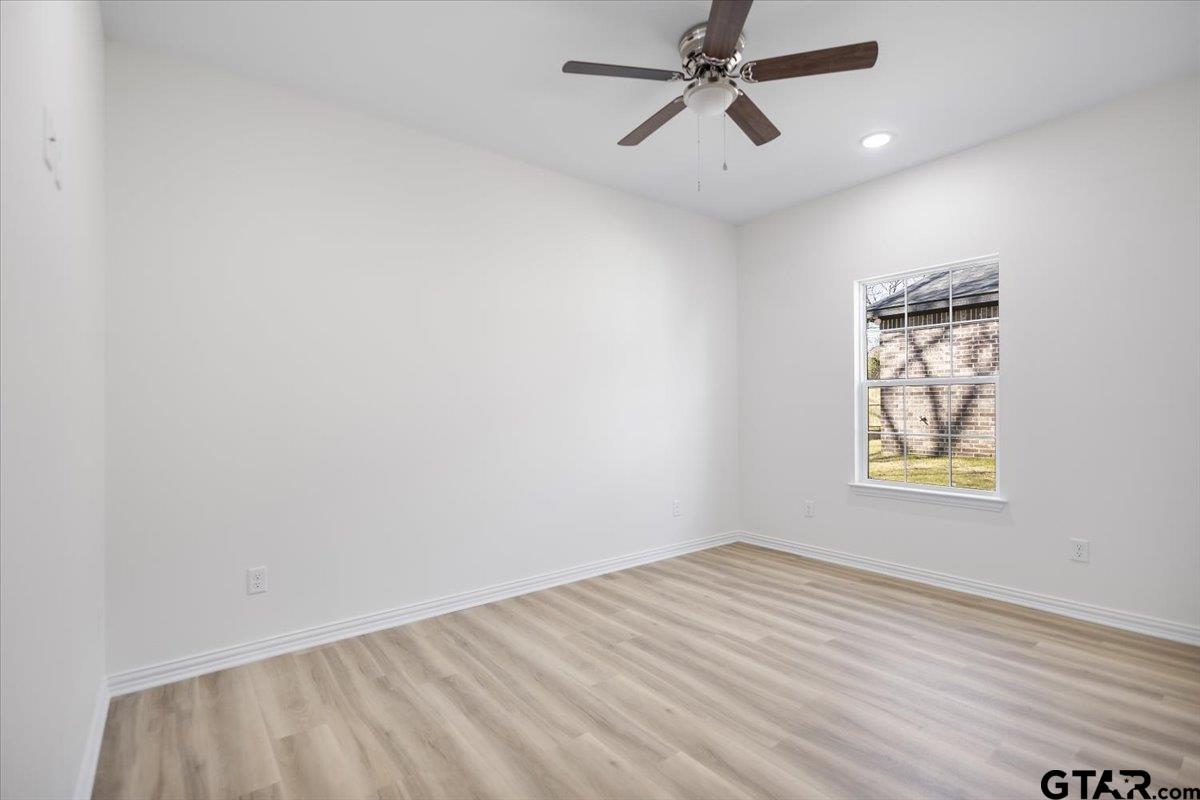 1310 West Claude Street Tyler, TX 75702 - Photo 19 of 27 an empty room with windows and fan