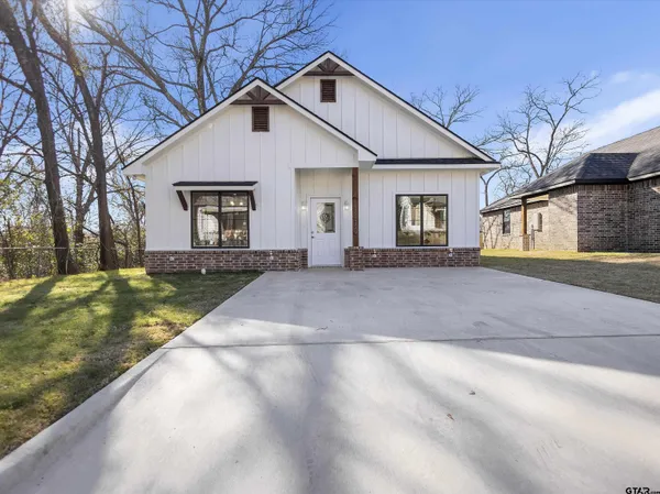 a front view of house with yard and trees around