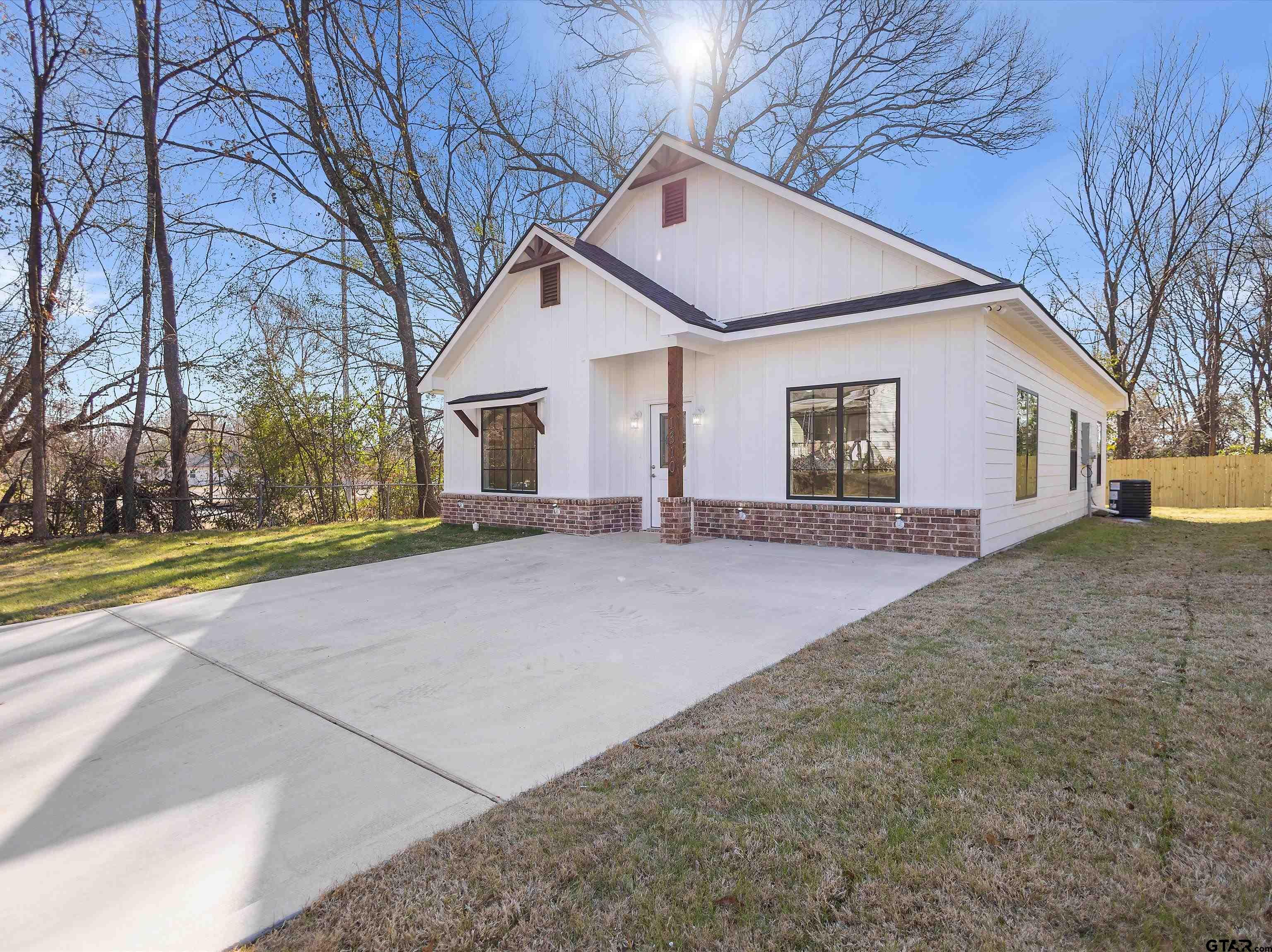 1310 West Claude Street Tyler, TX 75702 - Photo 4 of 27 a view of a white house with a yard and large tree