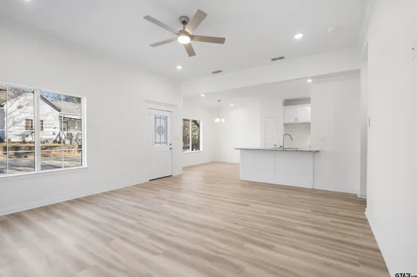 a view of an empty room with a window and wooden floor