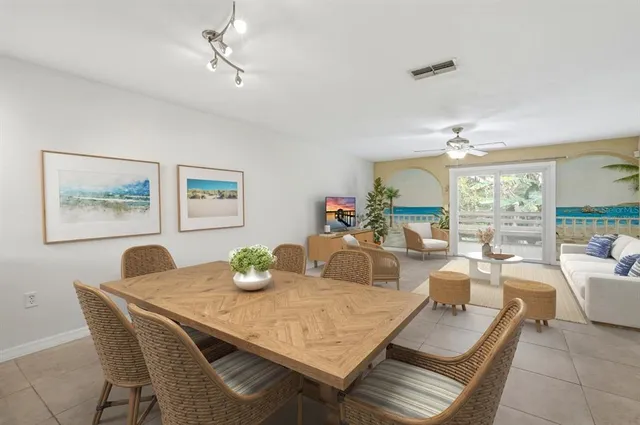 a dining room with furniture a large window and potted plants