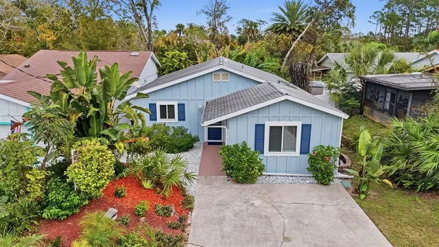 a view of a house with a yard and potted plants