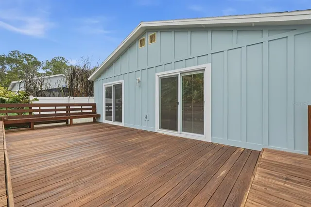 a backyard of a house with wooden floor and outdoor seating