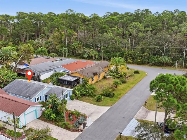 an aerial view of residential houses with outdoor space and trees