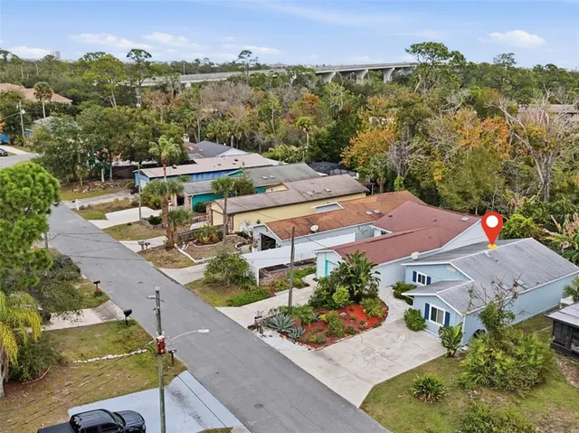an aerial view of residential houses with outdoor space and trees