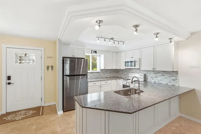 a kitchen with kitchen island a sink stove and refrigerator