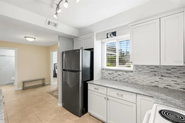 a kitchen with stainless steel appliances granite countertop a refrigerator and a sink