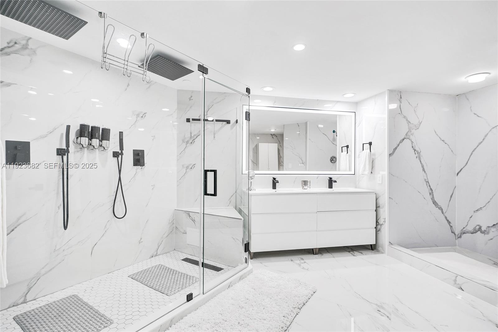 4000 Island Boulevard, Unit 2301 Aventura, FL 33160 - Photo 2 of 50 a bathroom with a tub sink shower and mirror