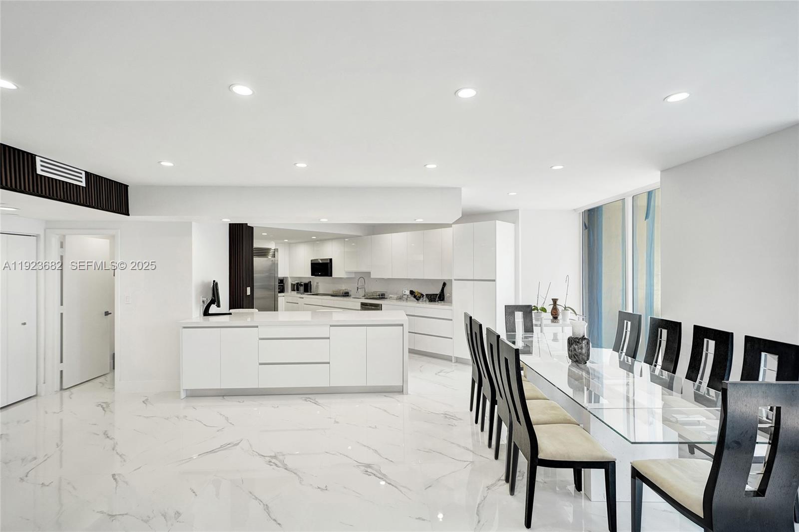 4000 Island Boulevard, Unit 2301 Aventura, FL 33160 - Photo 21 of 50 a kitchen with white cabinets and stainless steel appliances