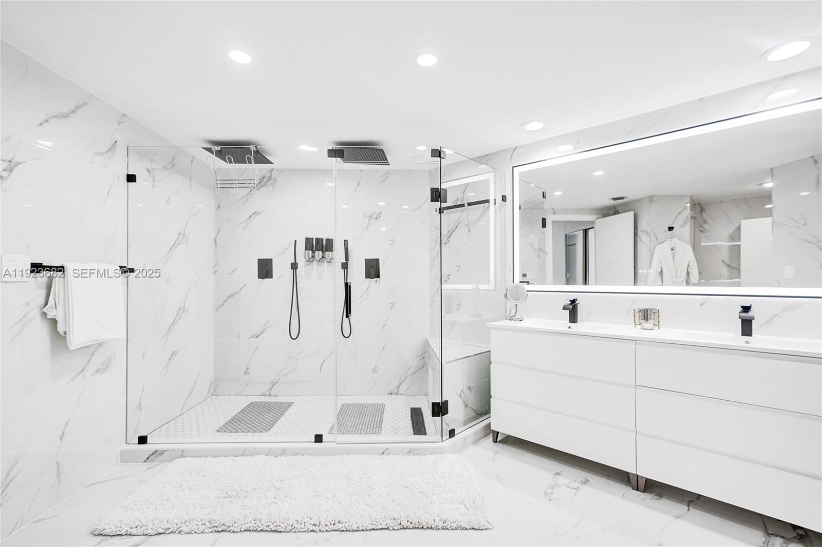 4000 Island Boulevard, Unit 2301 Aventura, FL 33160 - Photo 3 of 50 a large white bathroom with a double vanity sink mirror and shower