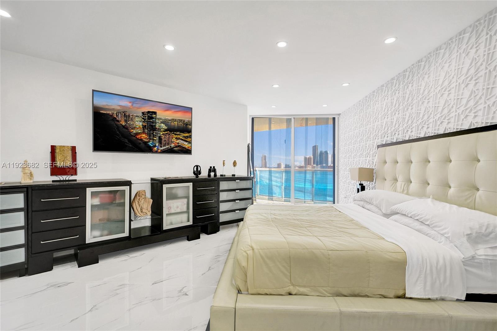 4000 Island Boulevard, Unit 2301 Aventura, FL 33160 - Photo 31 of 50 a bedroom with a bed and a flat screen tv