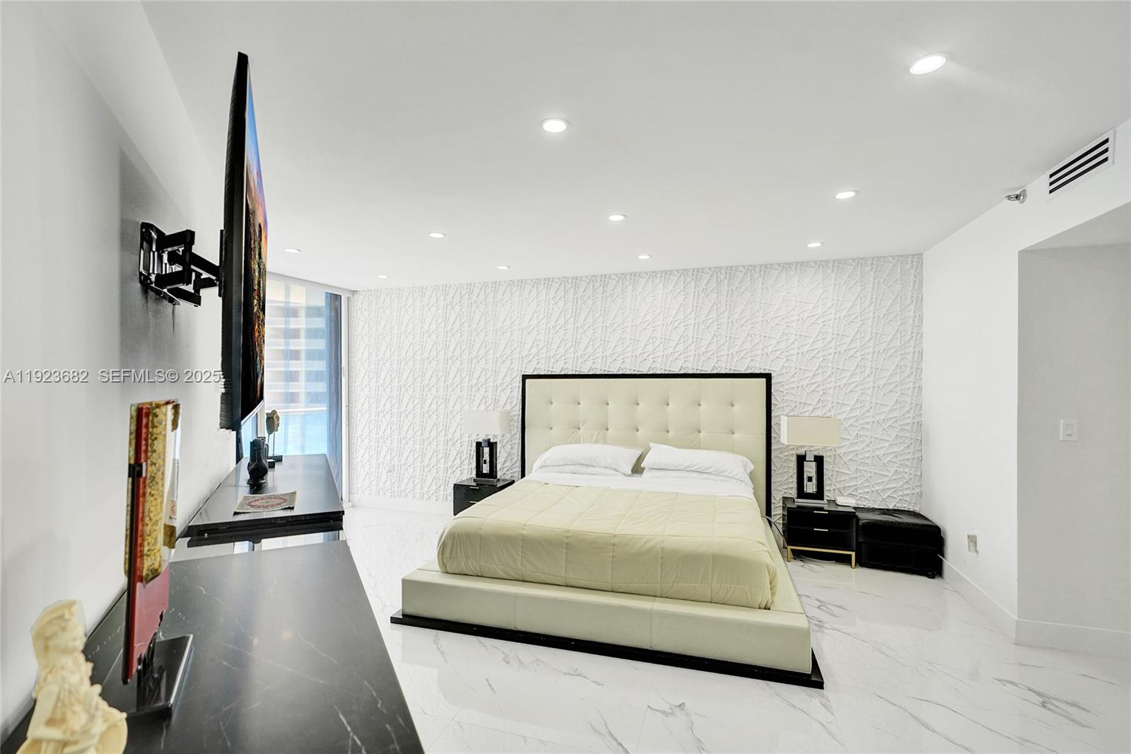 4000 Island Boulevard, Unit 2301 Aventura, FL 33160 - Photo 32 of 50 a bedroom with a bed and a large mirror