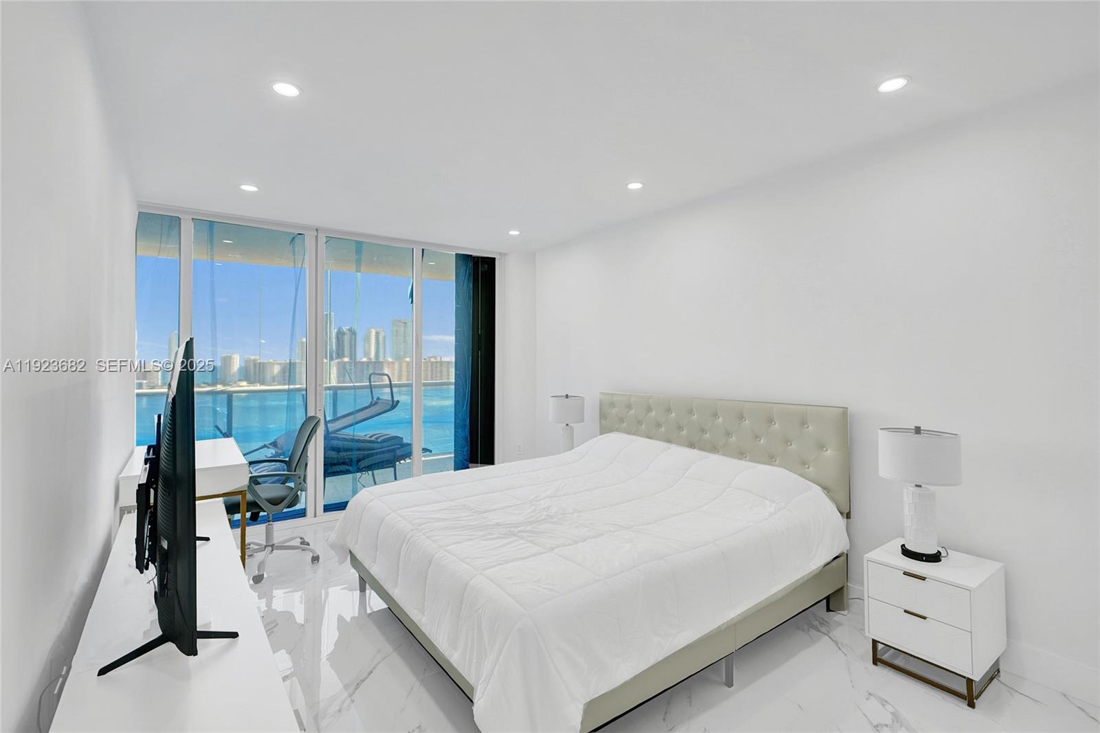 4000 Island Boulevard, Unit 2301 Aventura, FL 33160 - Photo 36 of 50 a bedroom with a bed and large windows