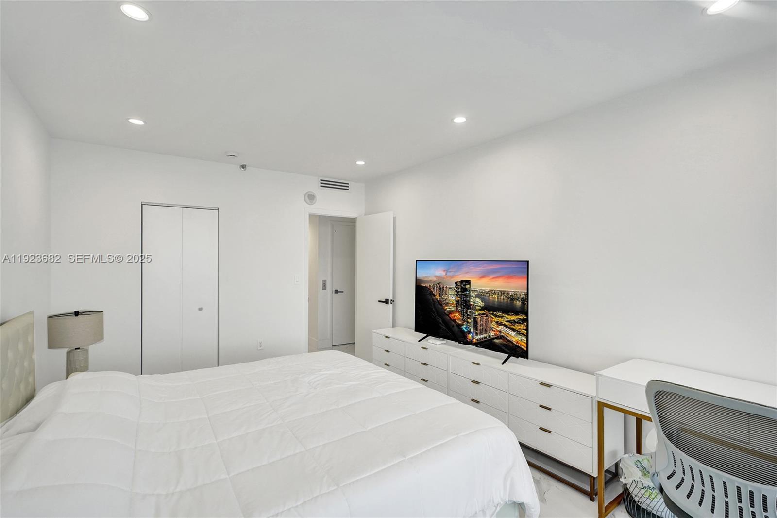 4000 Island Boulevard, Unit 2301 Aventura, FL 33160 - Photo 39 of 50 a bedroom with a bed and a flat screen tv