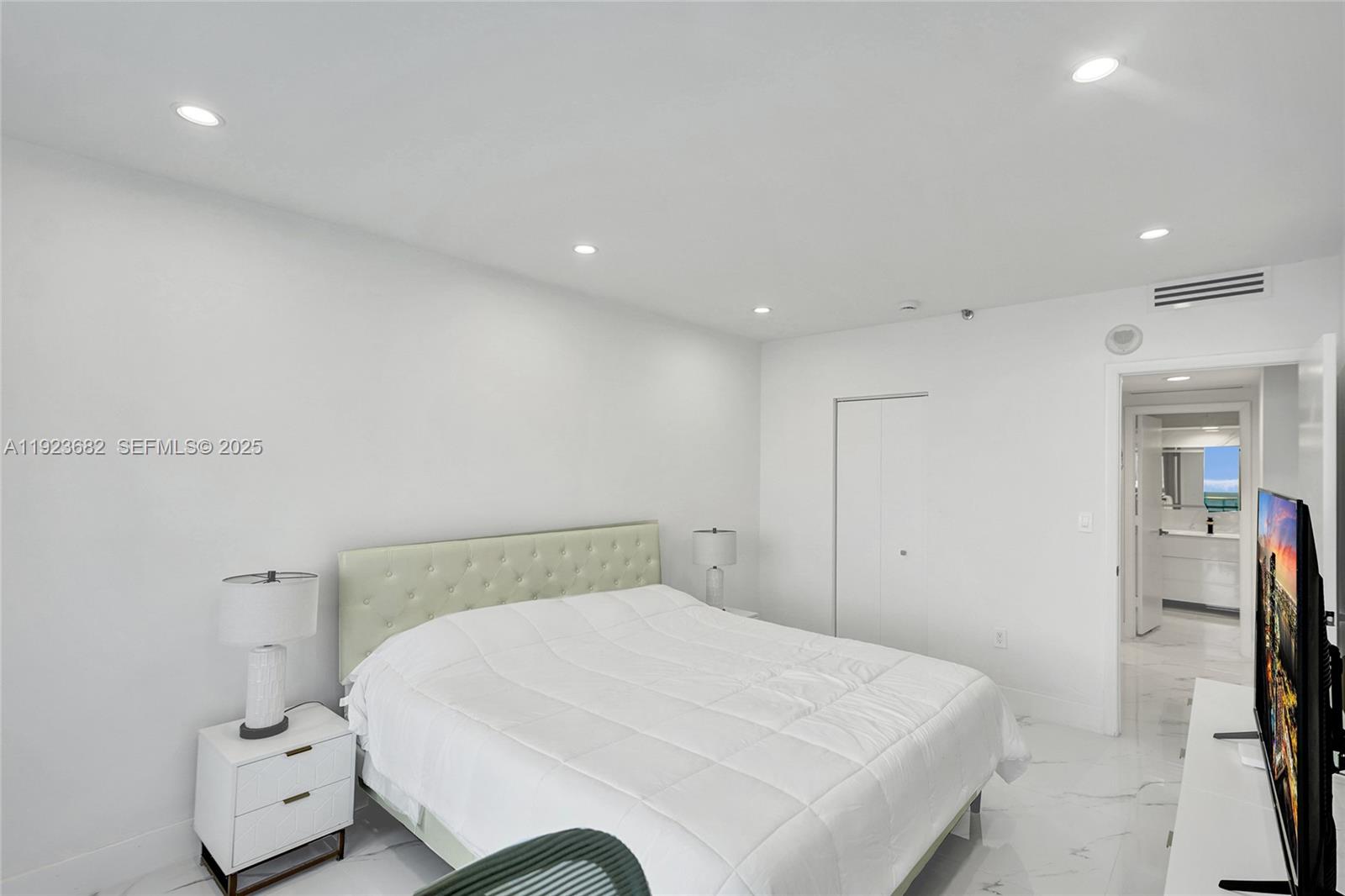 4000 Island Boulevard, Unit 2301 Aventura, FL 33160 - Photo 40 of 50 a bedroom with a bed and a large mirror