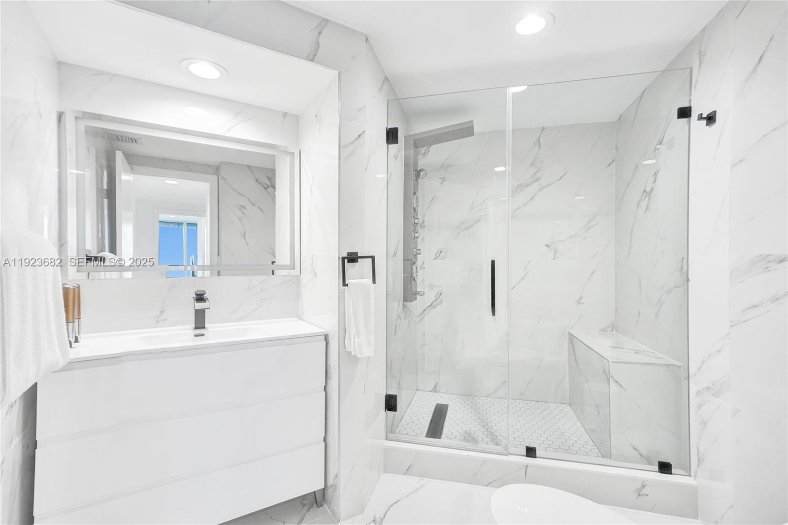 4000 Island Boulevard, Unit 2301 Aventura, FL 33160 - Photo 44 of 50 a bathroom with a bathtub shower sink and a mirror