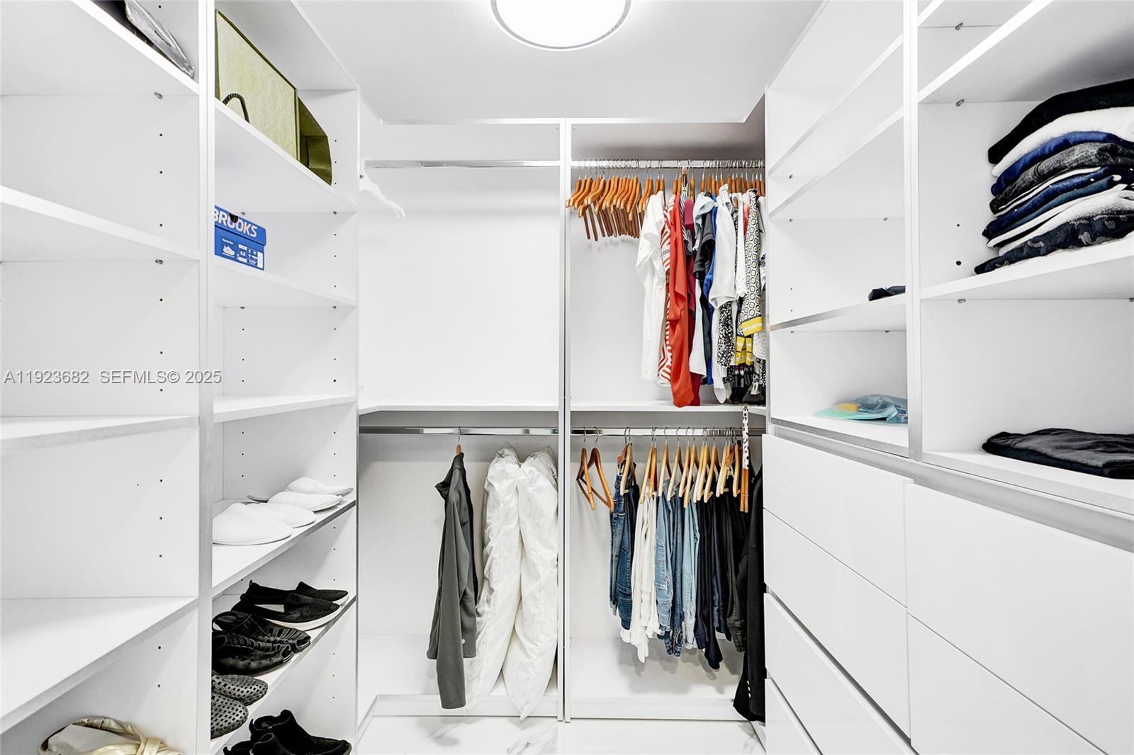 4000 Island Boulevard, Unit 2301 Aventura, FL 33160 - Photo 48 of 50 a view of walk in closet with clothes and shoes