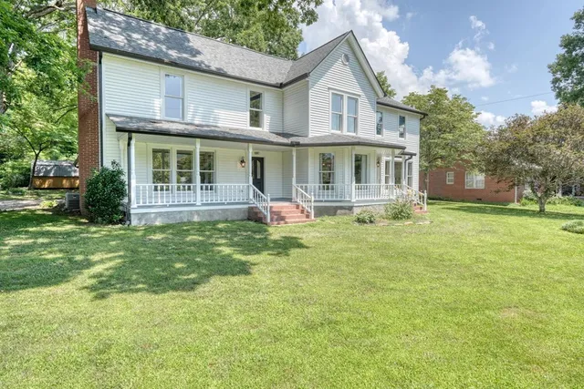 a front view of a house with a garden and porch