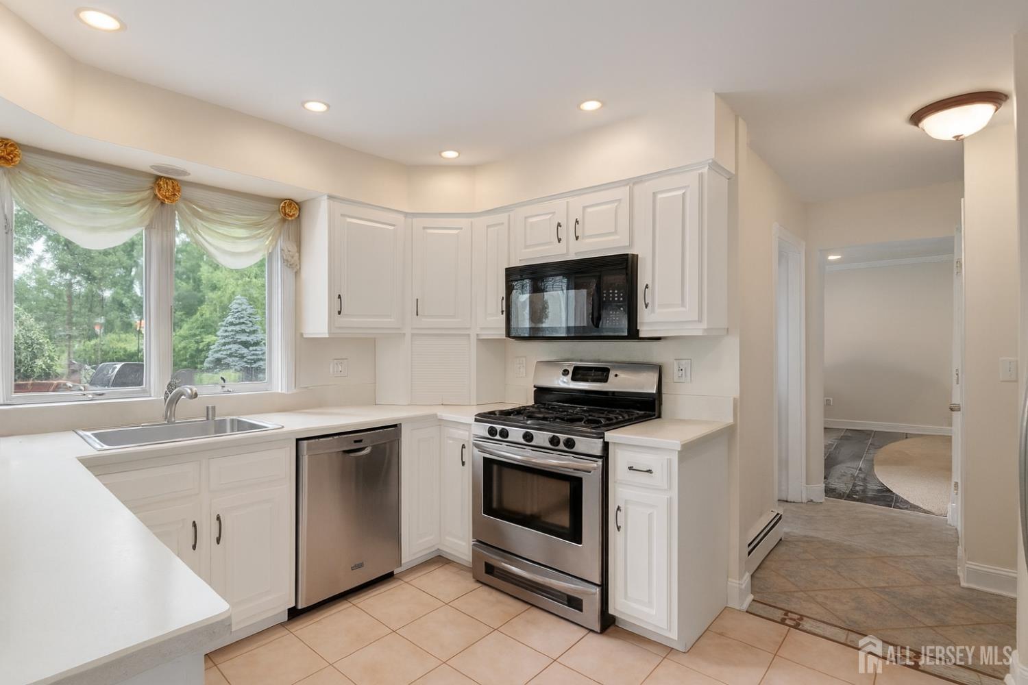 526 County Road, Unit 579 Ringoes, NJ 08551 - Photo 37 of 51 a kitchen with white cabinets appliances and a window