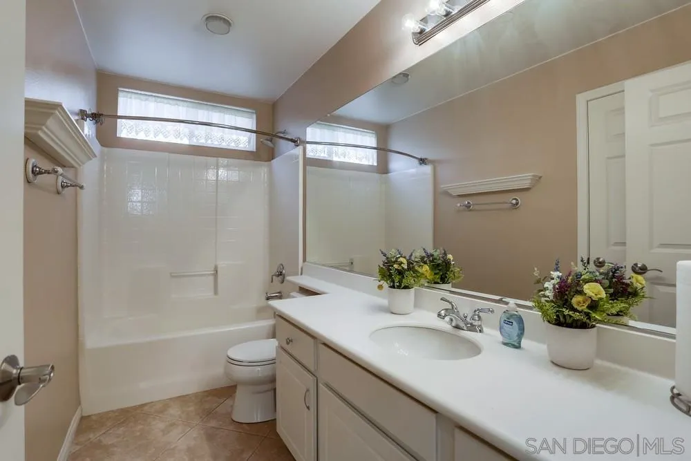 710 Greyfield Court Fallbrook, CA 92028 - Photo 11 of 28 a bathroom with a granite countertop sink a toilet and shower