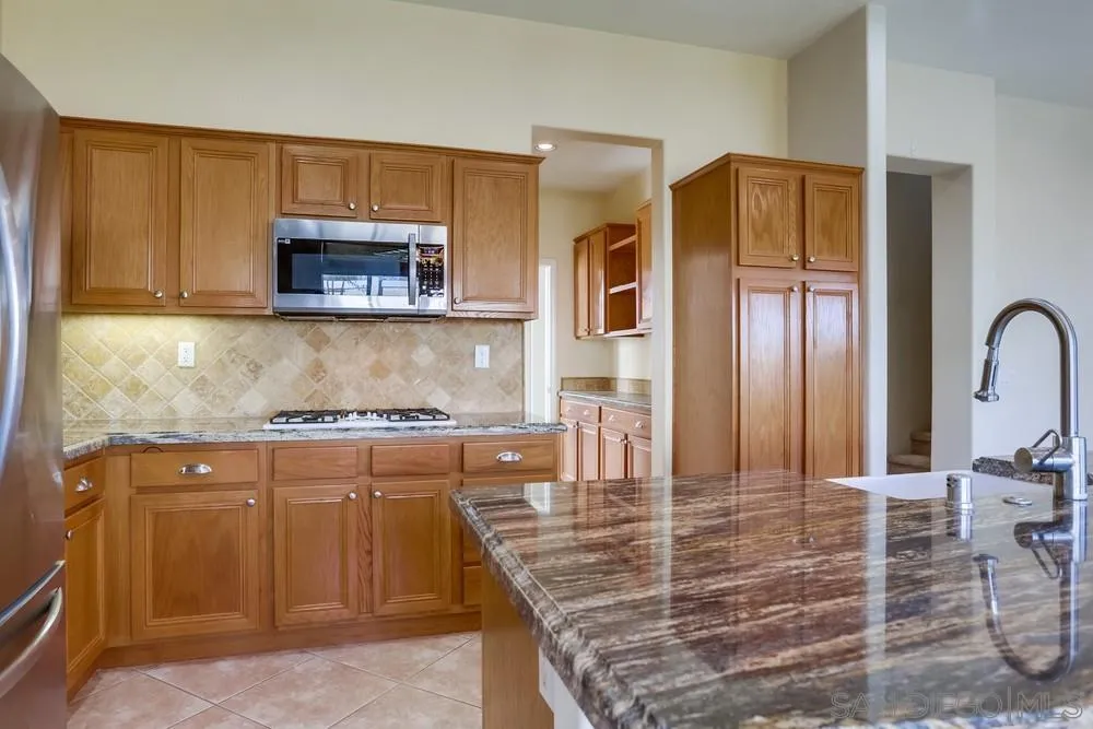 710 Greyfield Court Fallbrook, CA 92028 - Photo 13 of 28 a kitchen with stainless steel appliances granite countertop a stove a sink and a microwave