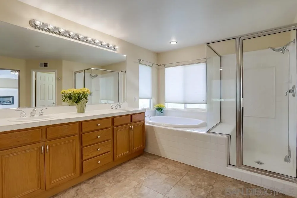 710 Greyfield Court Fallbrook, CA 92028 - Photo 18 of 28 a spacious bathroom with a double vanity sink a large mirror and a bathtub