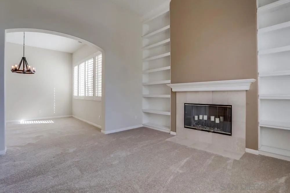 710 Greyfield Court Fallbrook, CA 92028 - Photo 9 of 28 a view of an empty room with a fireplace and a window